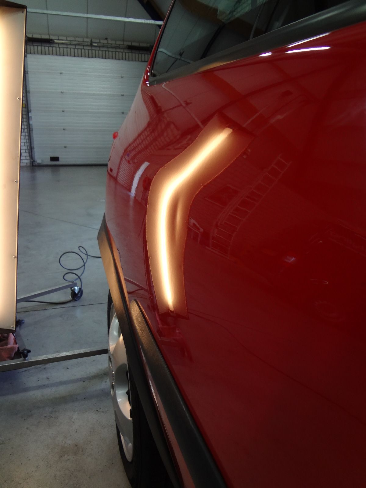 Een rood achterscherm met een deuk, bekeken met een lichtbalk